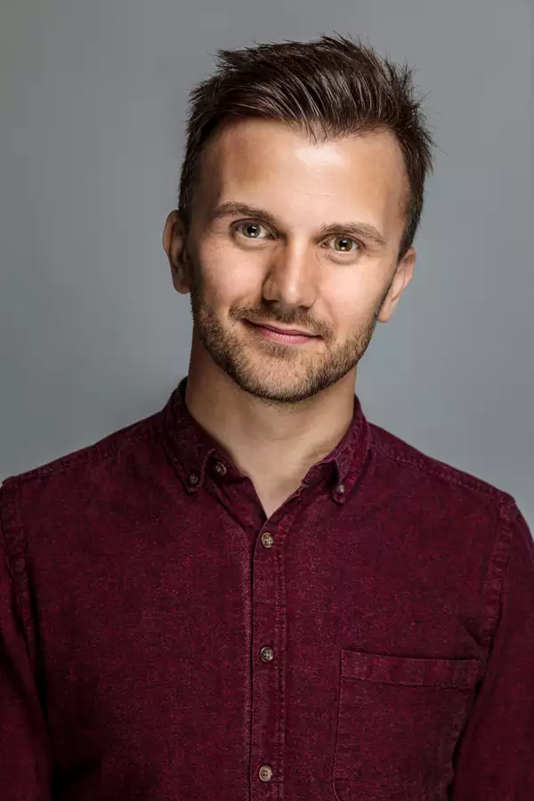 Richard Hay in a maroon shirt against a grey background