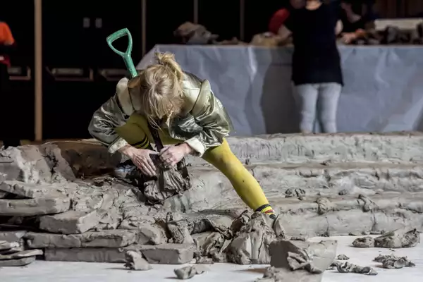 A performer building the clay installation during the Artist Takeover 2024