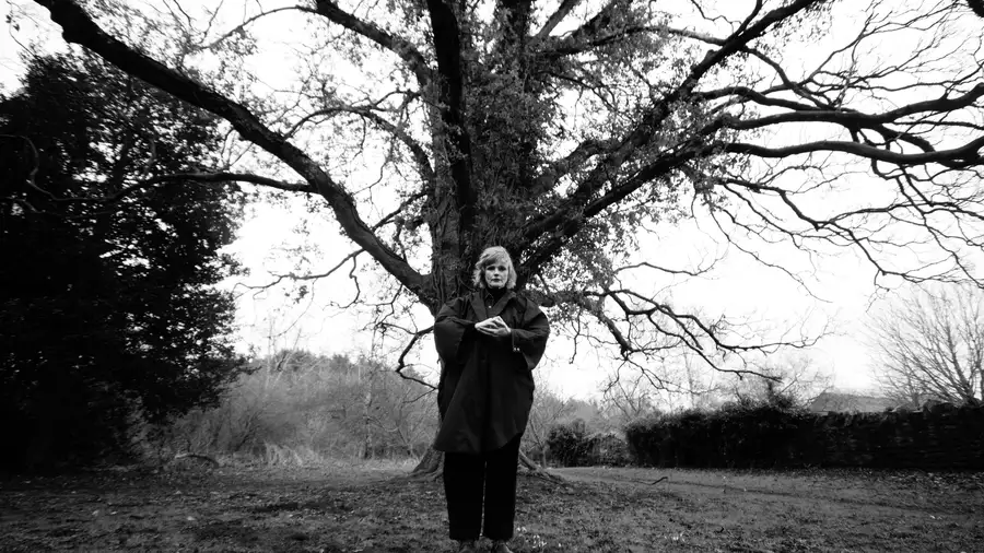 black and white photo of Maxine Peake stood in front of a large tree