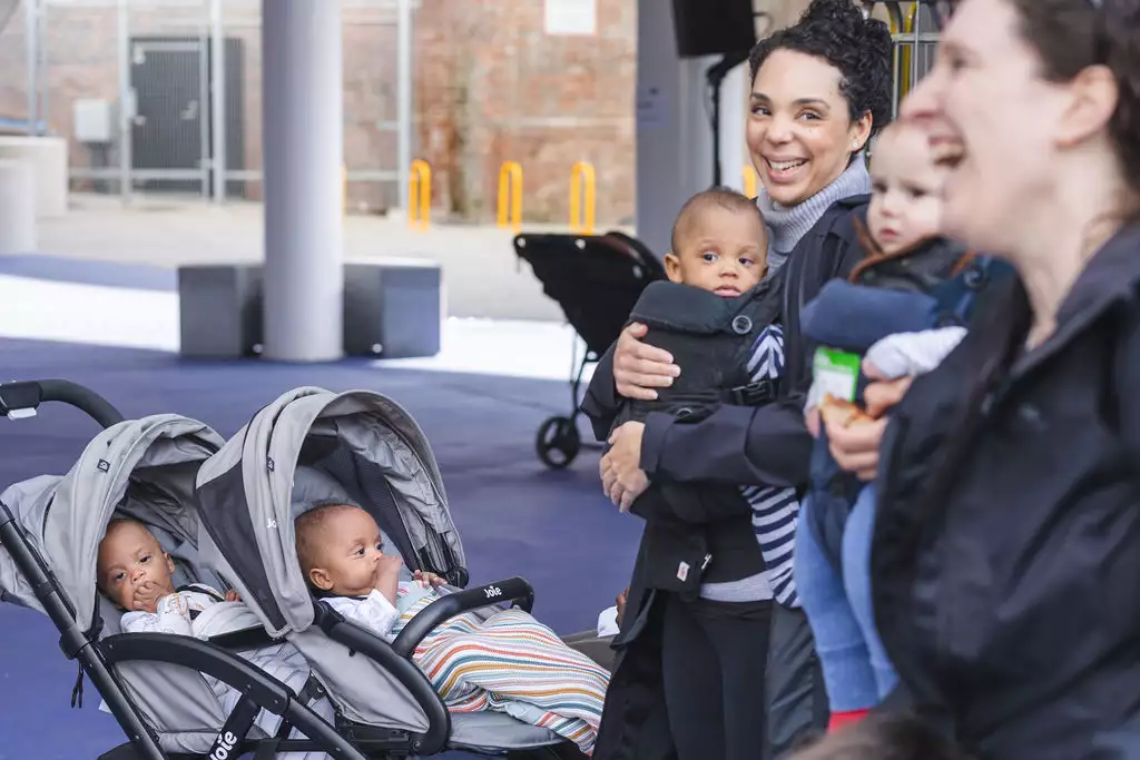 Two babies in a pram with their parents/carers
