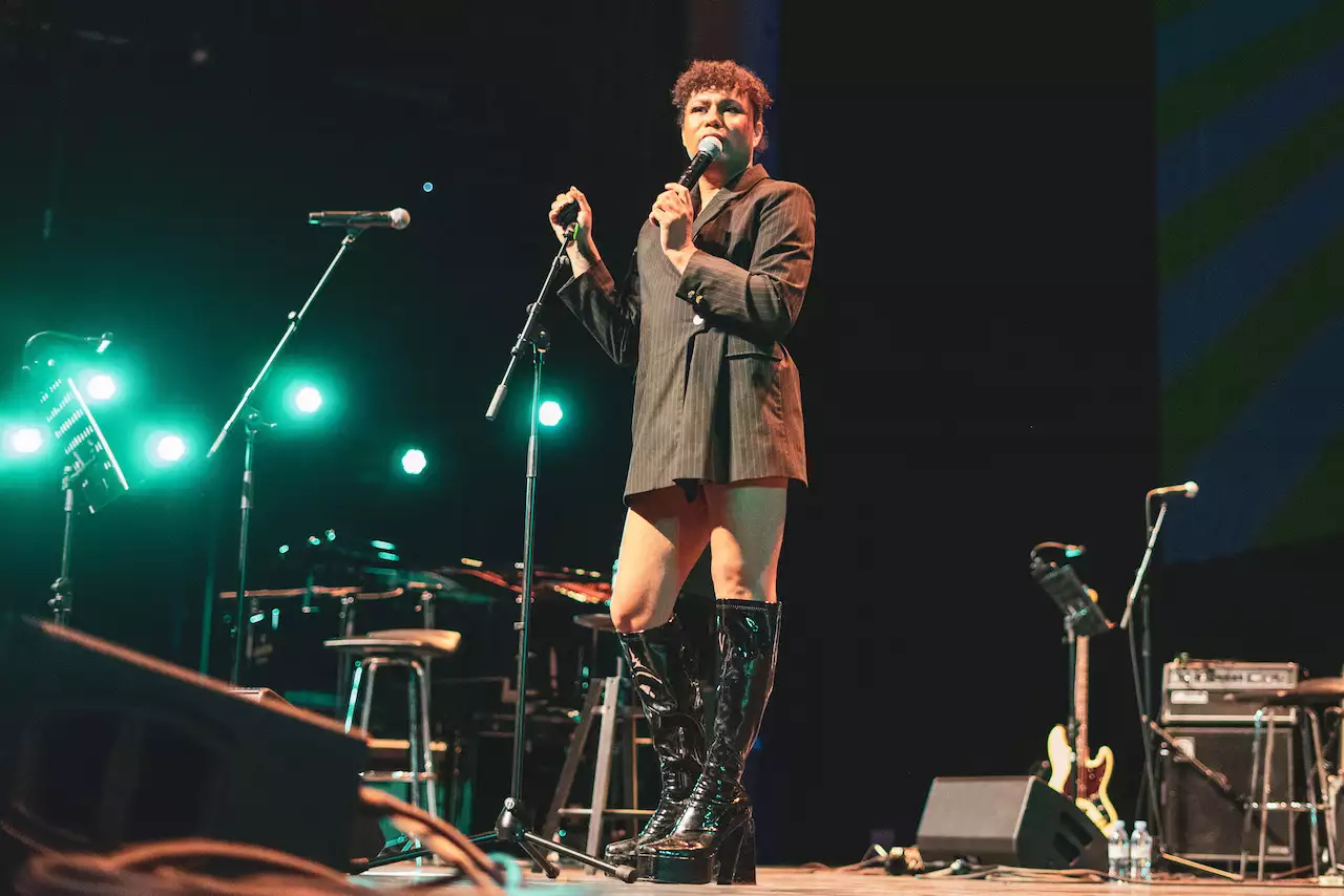 Photo of Travis Alabanza on stage with a microphone