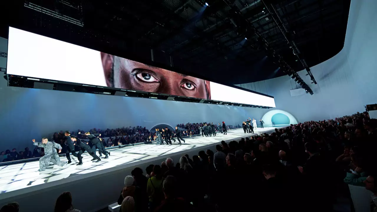 Dancers performing under a screen showing a person's eyes in Free Your Mind