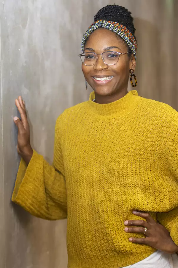 Portrait photograph of Sheri Lawal wearing a yellow jumper