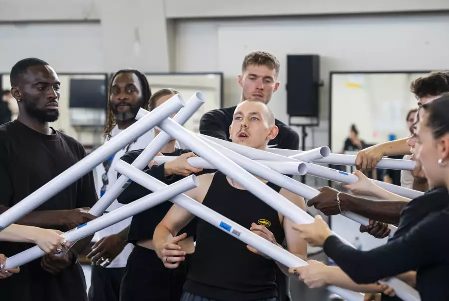 Dancers blocking another dancer with white plastic tubes in rehearsals for Free Your Mind