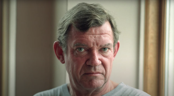 a screenshot of a video showing a close-up image of the art critic Robert Hughes.