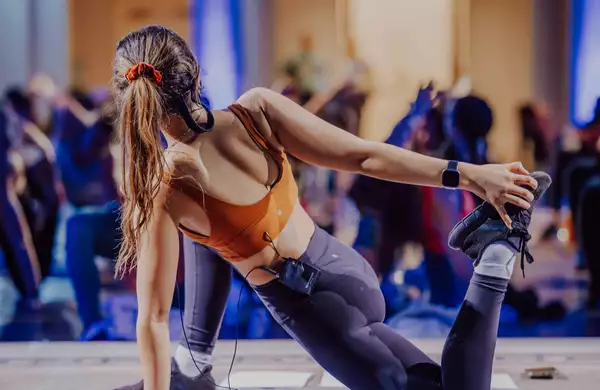 A person doing a yoga pose, leading a class