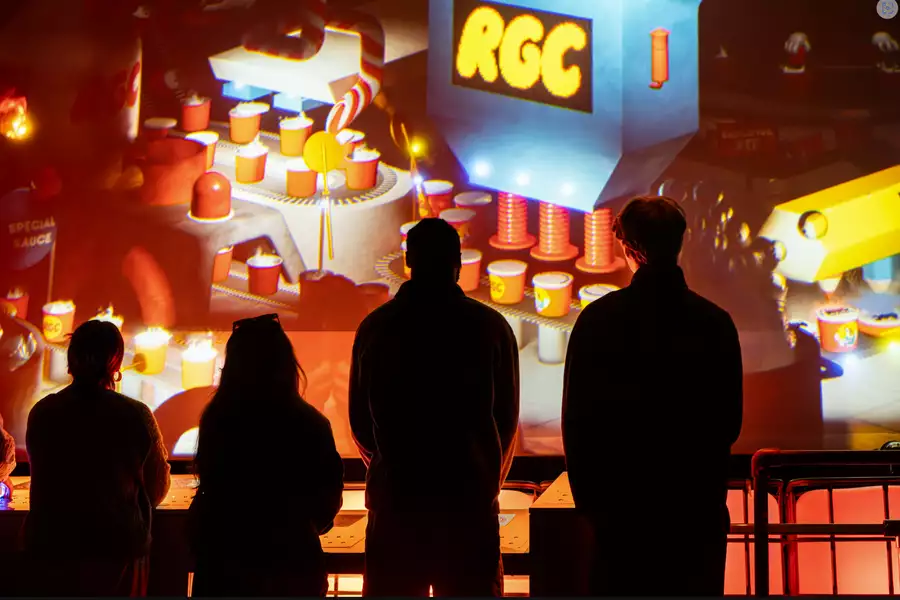 Silhouettes of people in front of a wall of digital art