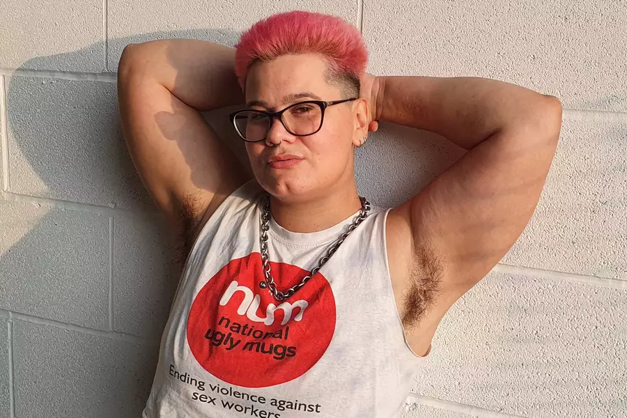 Photo of DJ Duckdown with arms raised against a breezeblock wall