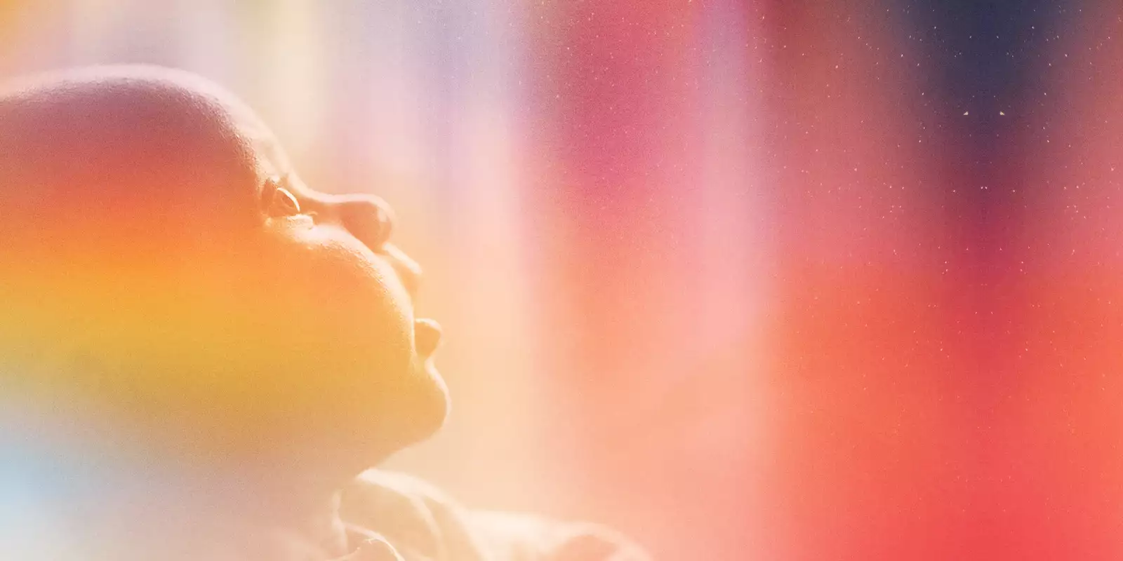 A photograph of a baby staring up in wonder at the night sky