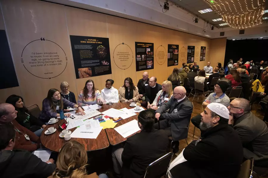 Groups of people sat around big circle tables in discussion