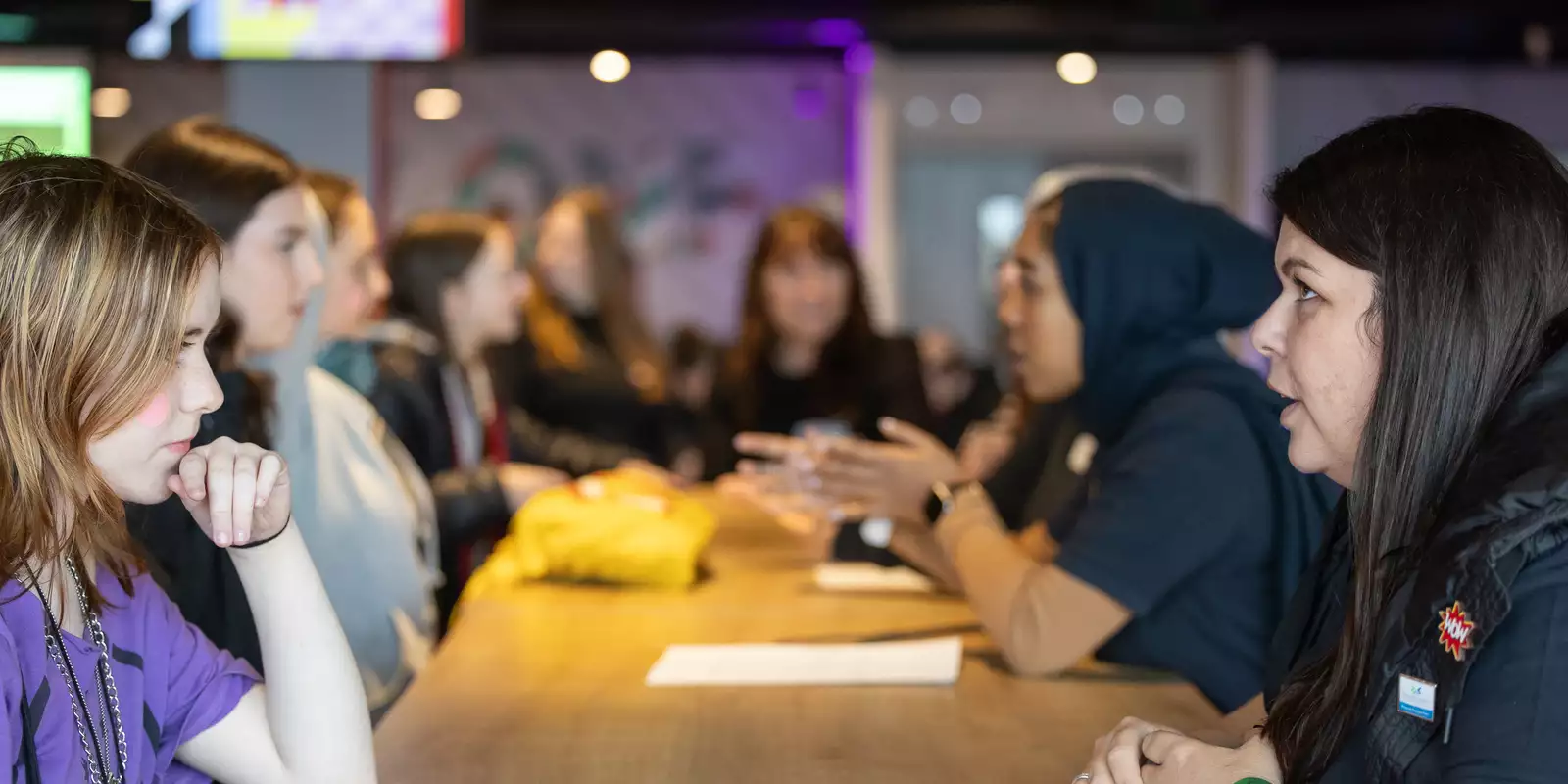 Mentors and mentees talking on a long table