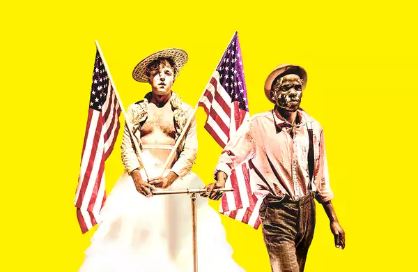 Two people holding two American flags on a yellow background