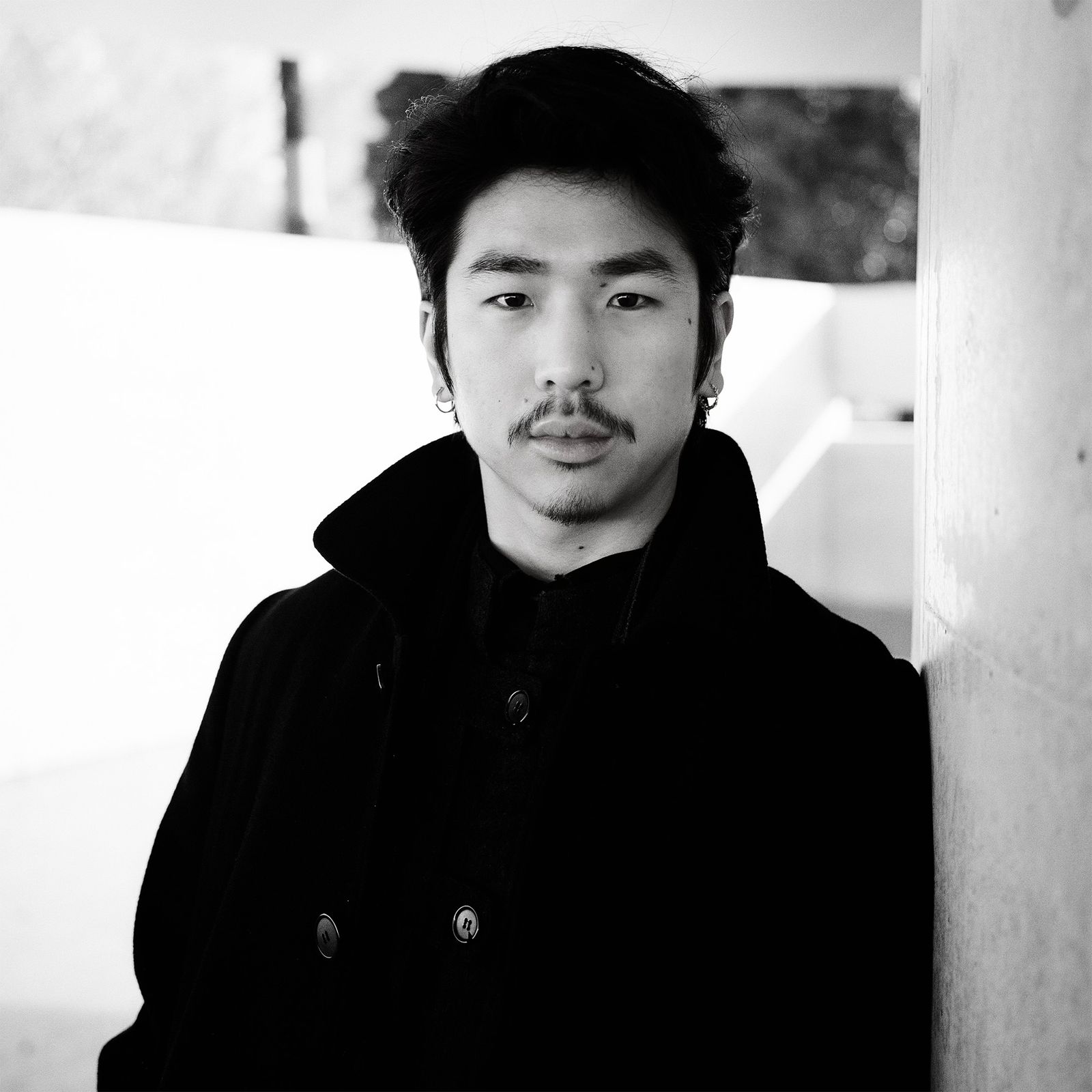 A black and white photograph featuring the head and shoulders of Leon Zhan