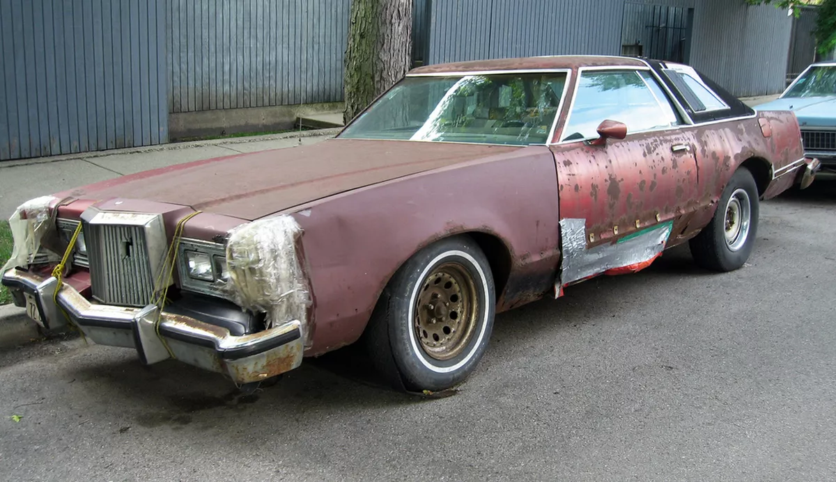 Very old, beaten-up car held together with tape and string