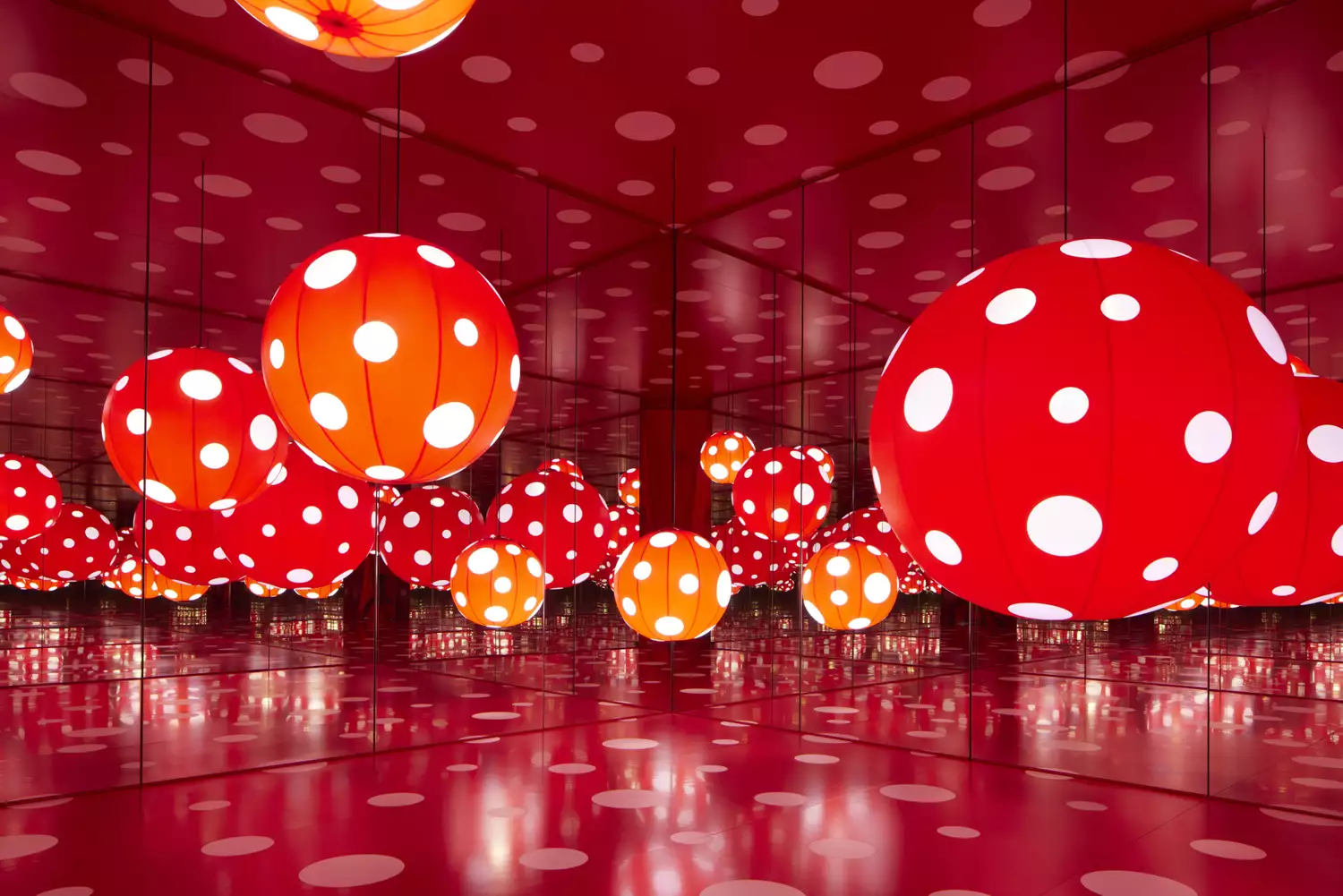 Red and white polka dot spheres in a mirrored room