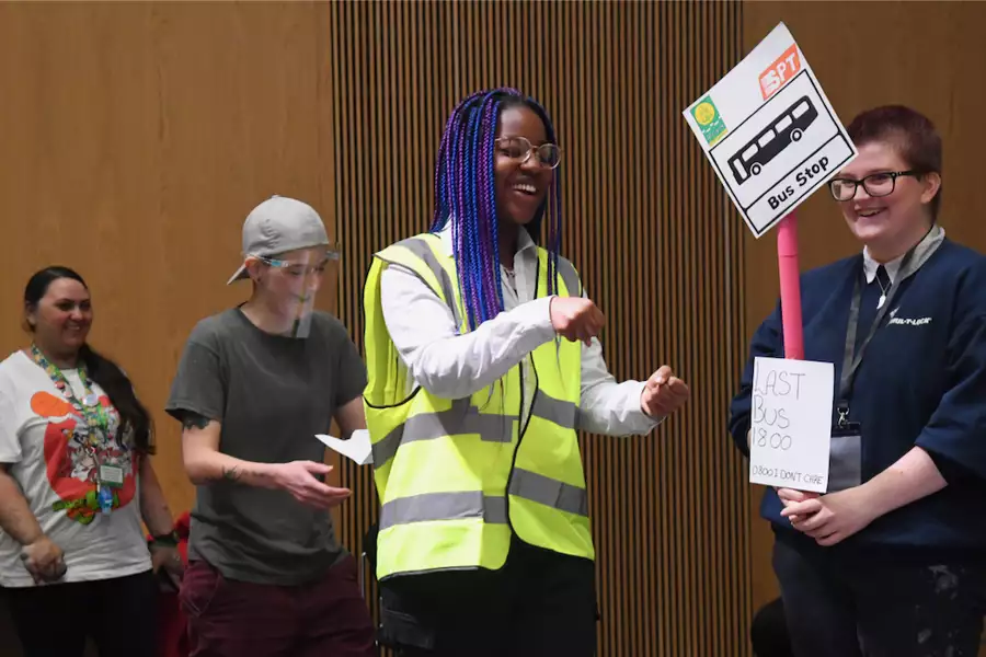 Two people dressed up as a bus conductor and bus stop