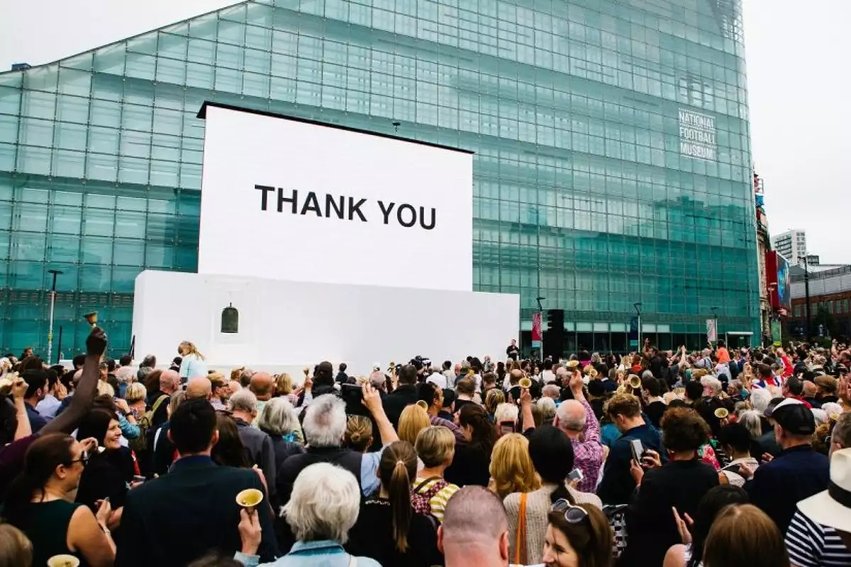Crowd of people in front of a glass building.