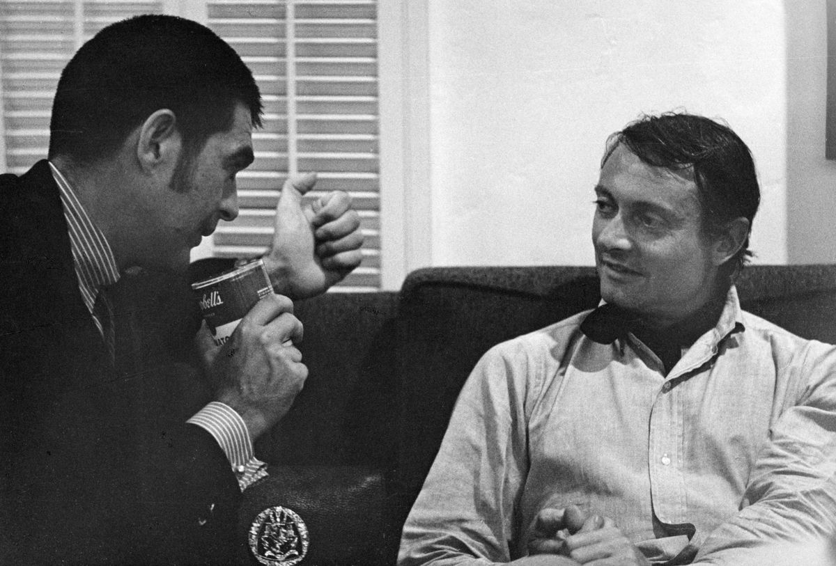 Gallerist Irving Blum appears to talk into a Campbell's soup can with the artist Roy Lichtenstein, Los Angeles c.1968