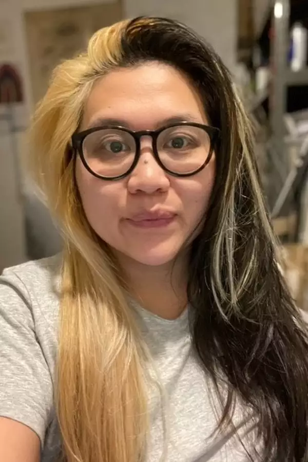 Jean Chan wearing black rimmed glasses and a grey t-shirt