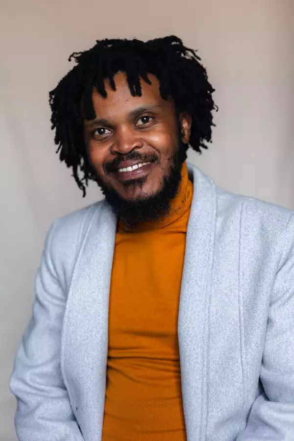 Bongani Bennedict Masango in a blue jacket and orange polo neck