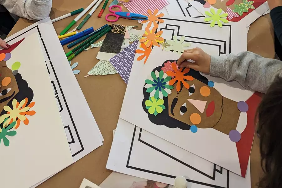 Children making collages of Frida Kahlo on a table