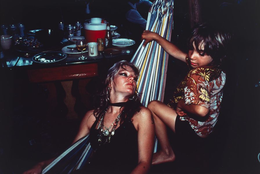 Cibachrome colour photograph of a mum with blonde hair lying on a hammock, with her son on the right