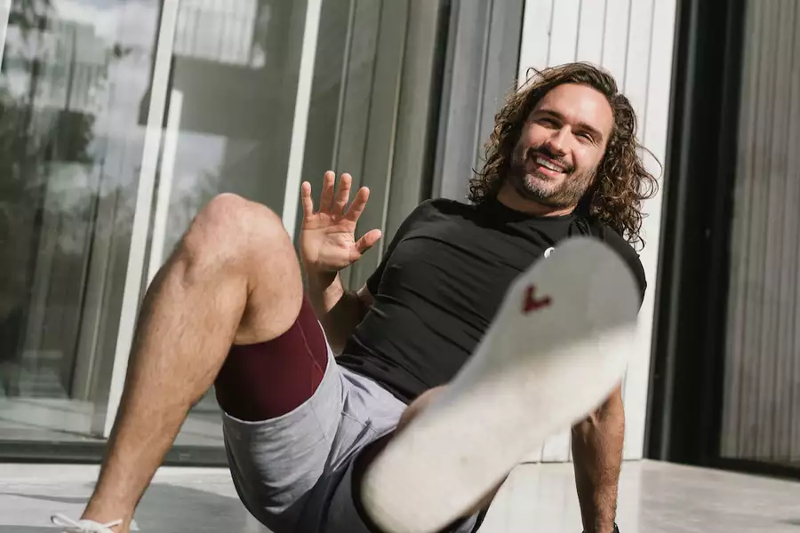 Joe Wicks crouching and looking at the camera
