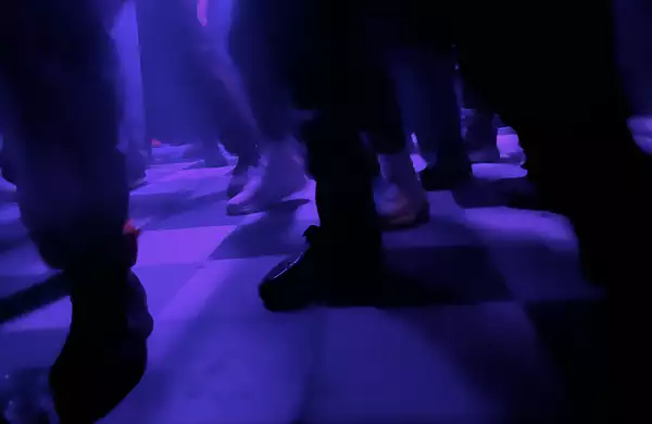 Checkered dancefloor lit up with purple lights