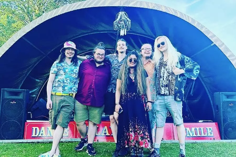 Photo of the band Wingspread stood in front of a stage