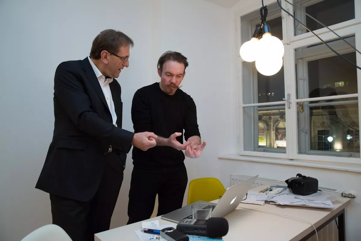 Josh Harle and another person observing looking at a laptop screen.
