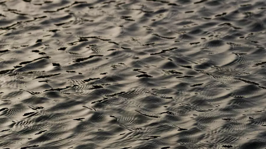 This image shows textured ripples on water. Light is reflecting off the water.