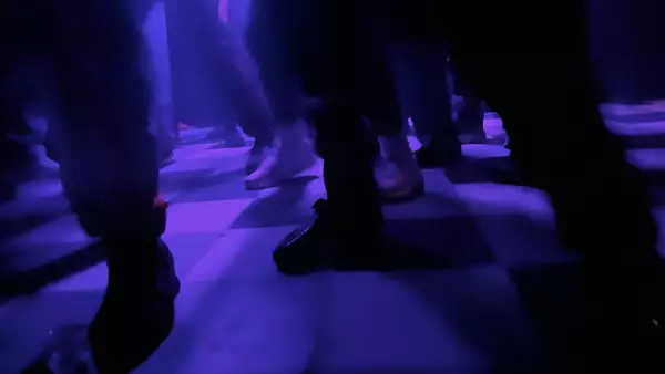 Checkered dancefloor lit up with purple lights