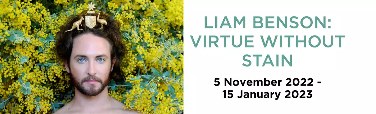 an image of artist Liam Benson with the Australian coat of arms on his head, wattle behind him, and the words Liam Benson Virtue Without Stain 5 November 2022 to 15 January 2023