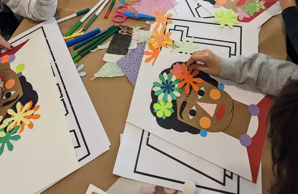 Children making collages of Frida Kahlo on a table