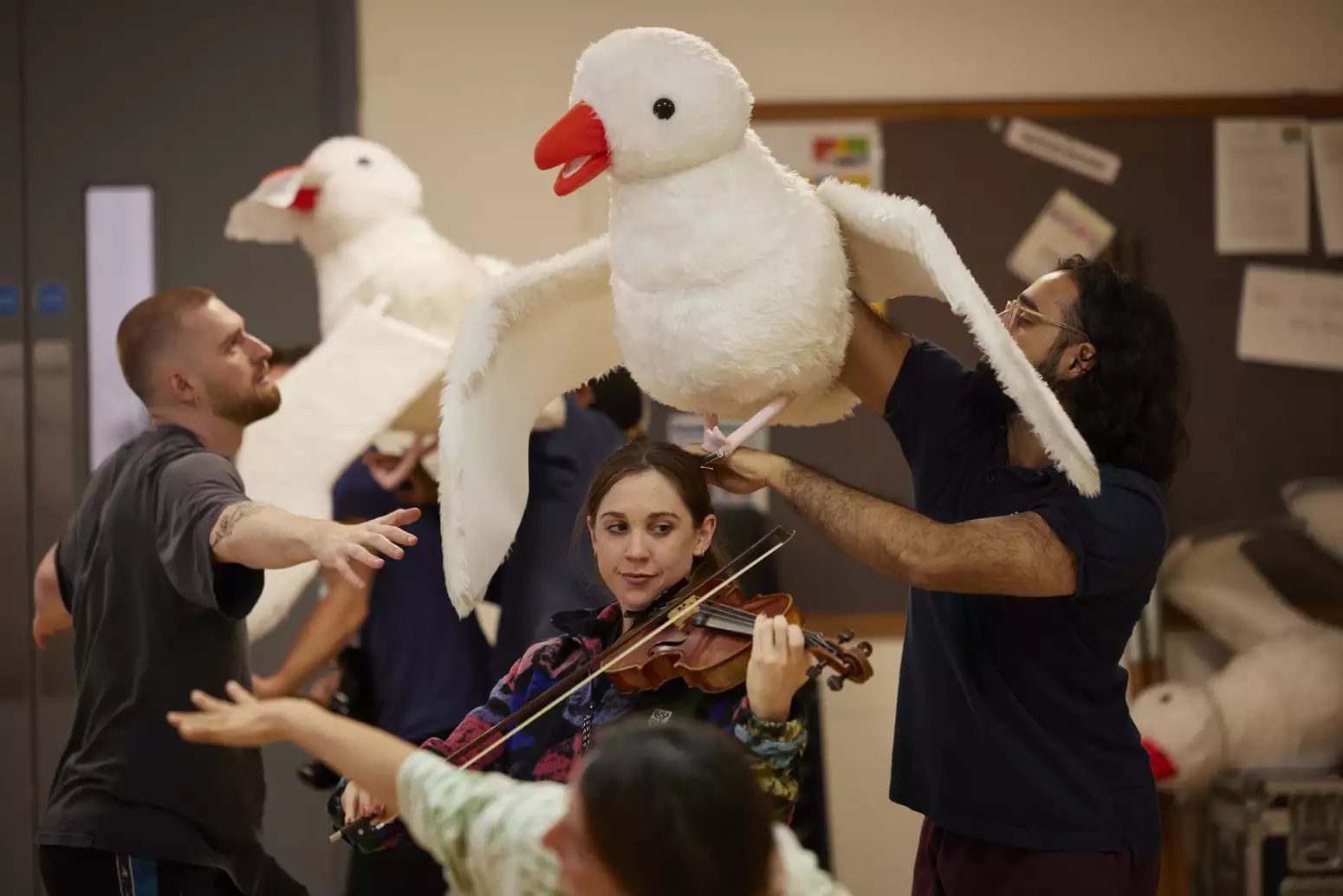 Violinist playing underneath a seagull puppet