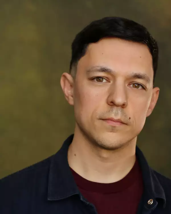 Headshot of James Cooney wearing a red top and denim shirt