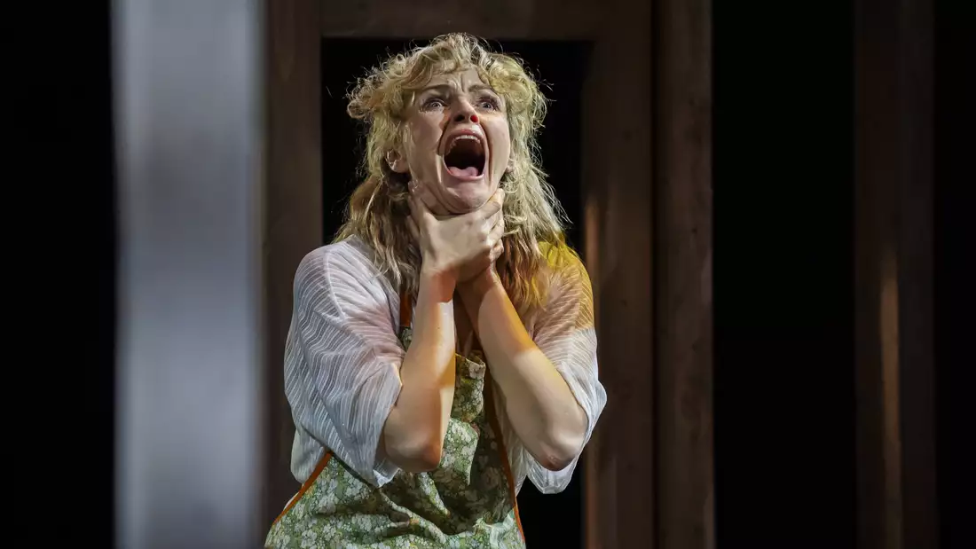 Woman wearing white apron holding her throat and screaming