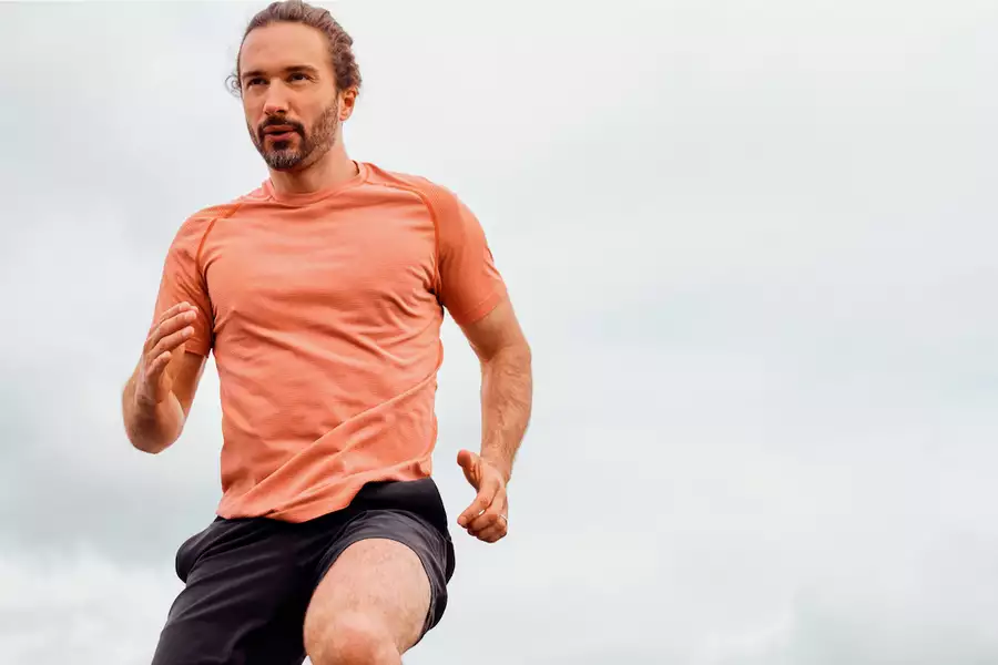 Joe Wicks running in an orange t-shirt