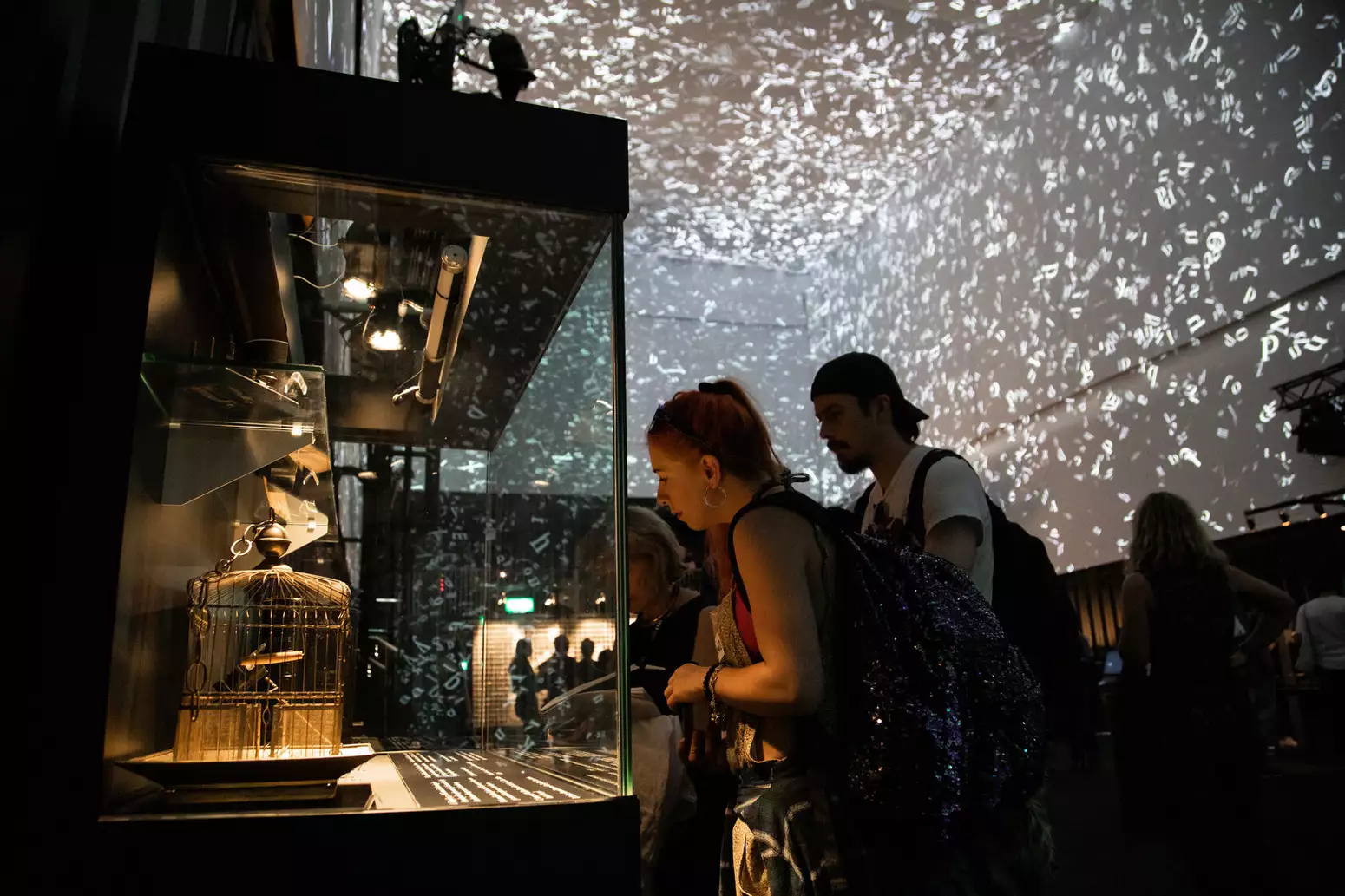 Two people look at a cabinet in an exhibition space