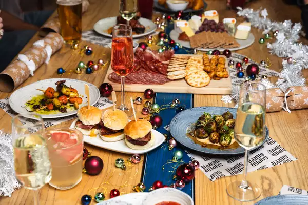 A festive table setting featuring a selection of Christmas Mezze, drinks, decorations and silver tinsel