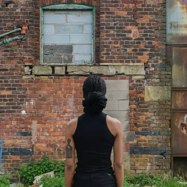 Photograph of Benedicte Tee with their back turned