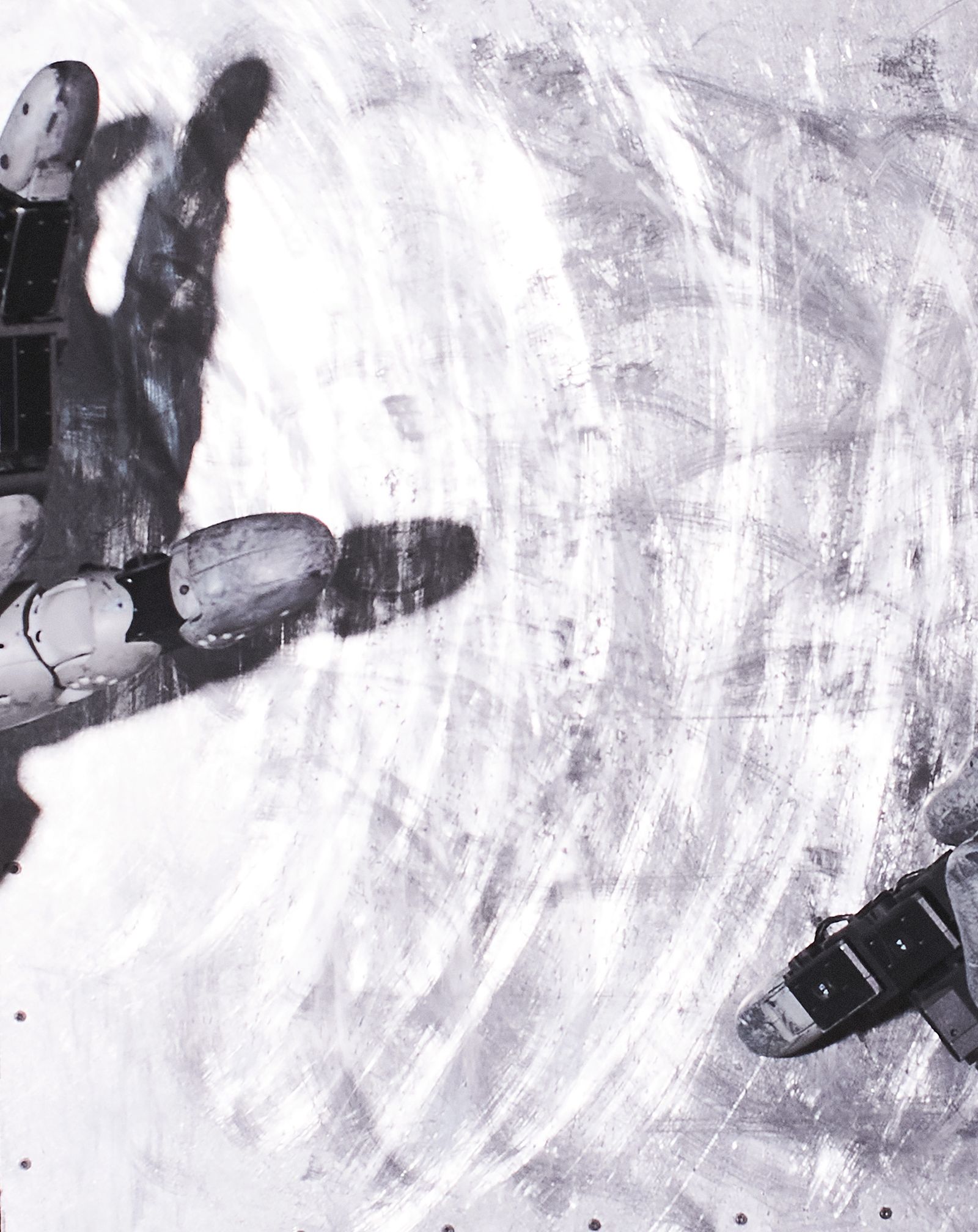 A tight crop of a black and white picture depicting robotic hands clawing