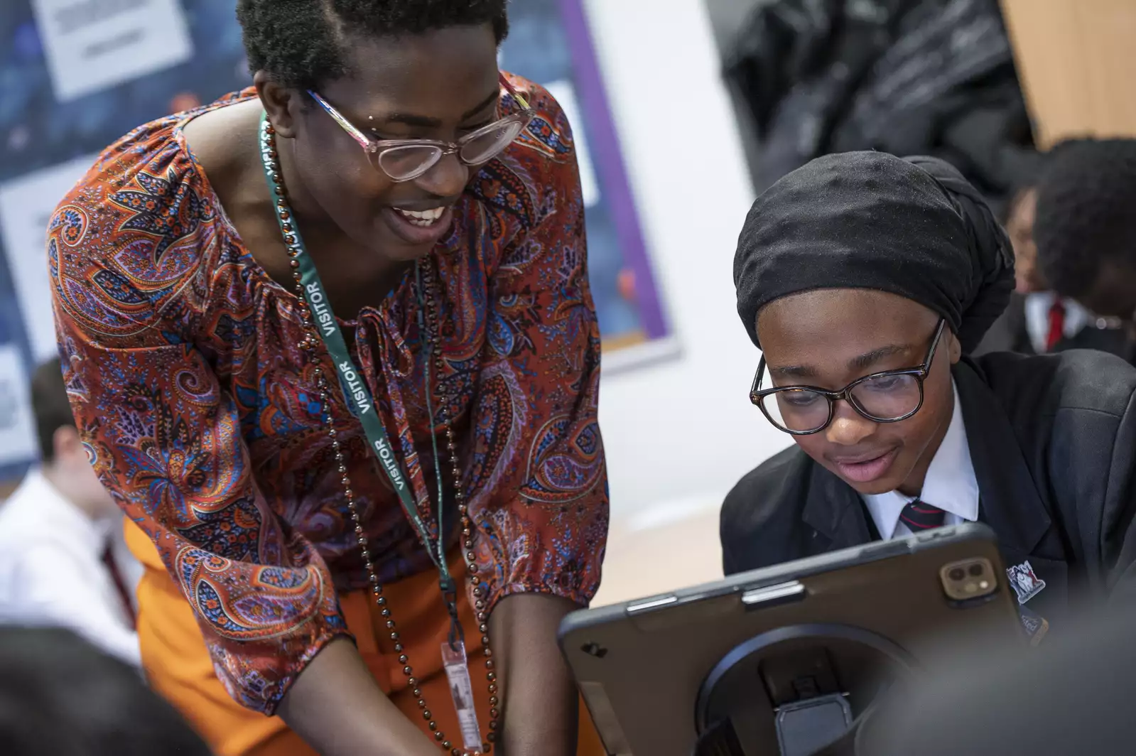 A teacher helping a child use an iPad
