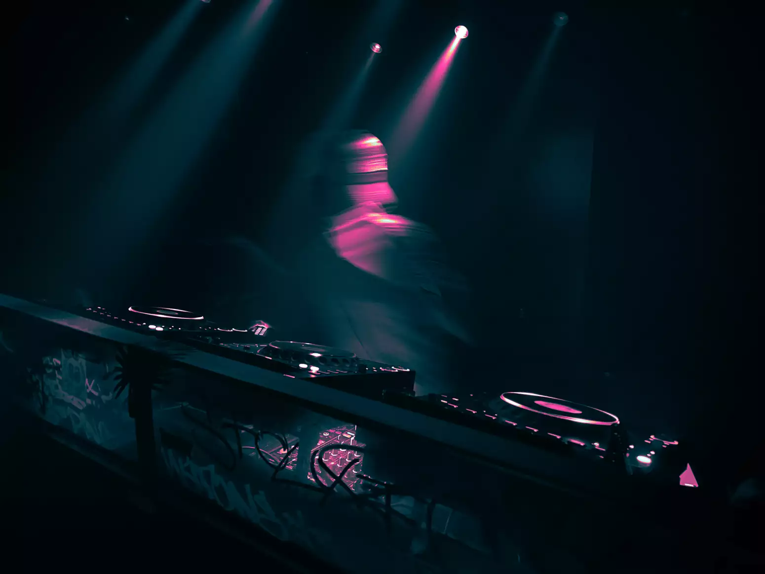 A person dancing behind DJ decks