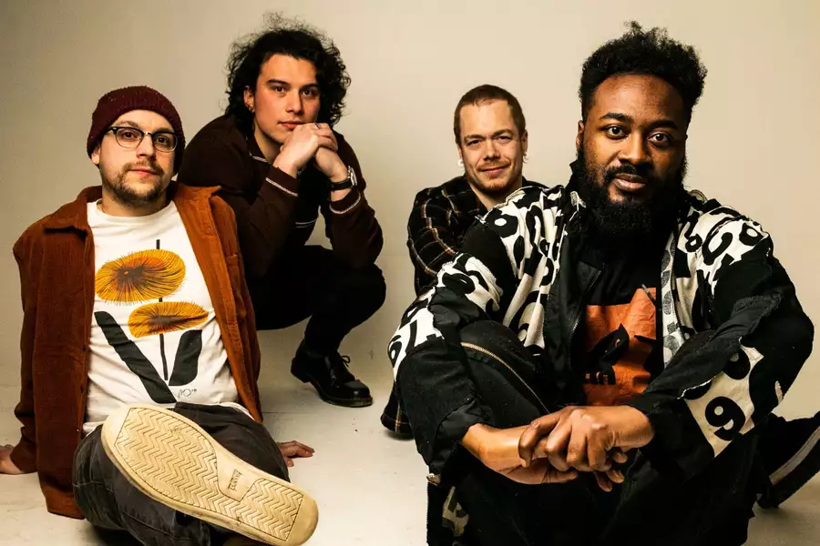 4 members of the band good grief relaxed sitting on the floor