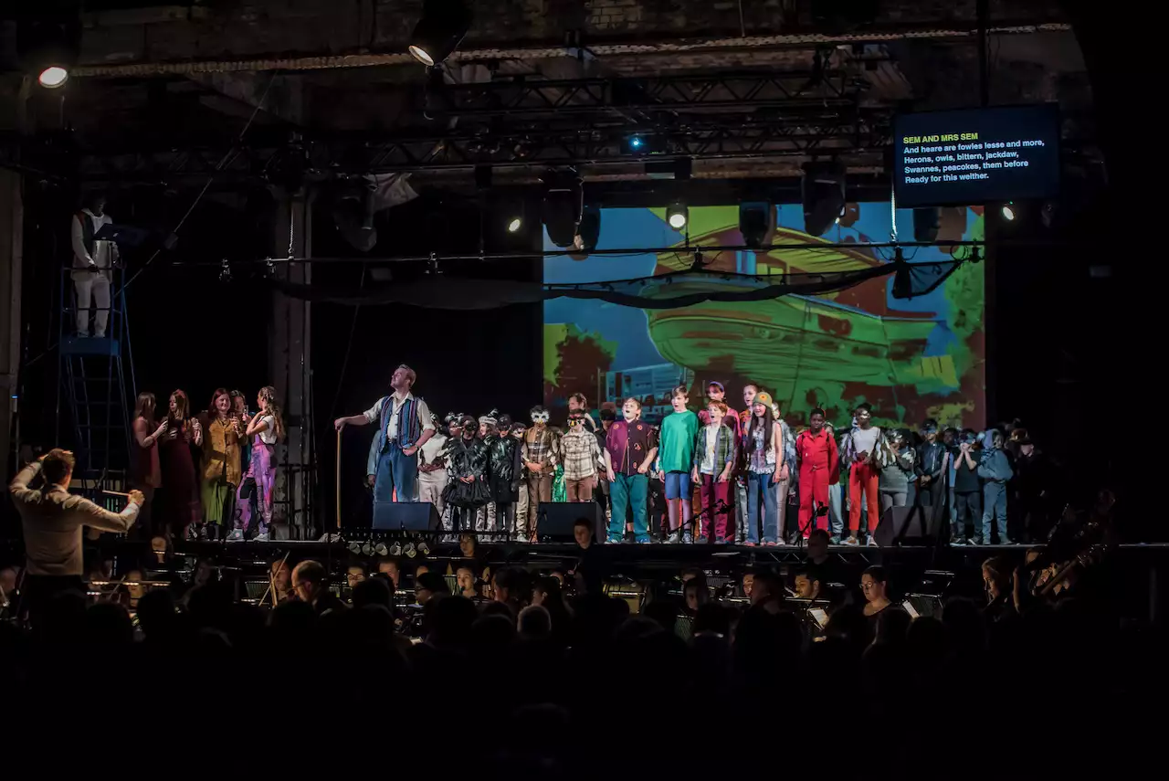 Photo of the cast of Noah's Flood on stage with orchestra