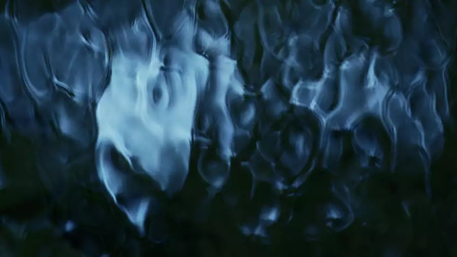 This image has an abstract, fluid-like pattern with deep blue and black tones, creating a sense of flowing water or rippling textures.