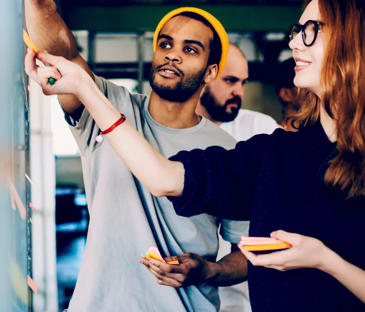 Two people stick post-its on a whiteboard