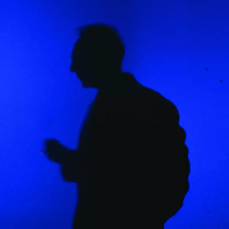 The shadow of a man on a bright blue background