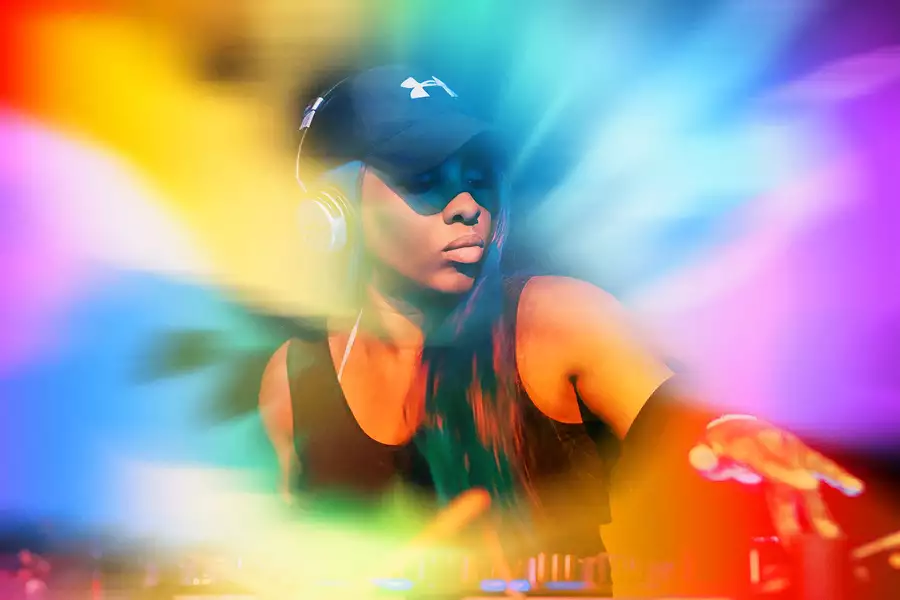 DJ Sequinella with a rainbow background